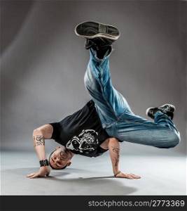 pohto of break dancer who is performing his dance on the floor