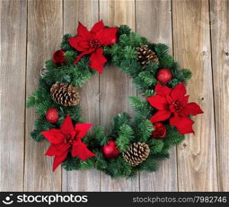 Poinsettia flower Christmas wreath on rustic cedar wood.