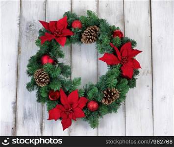 Poinsettia flower Christmas wreath on rustic white wood.