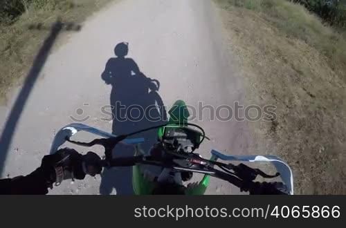 Point of View: Enduro rider riding motorcycle on dirt track