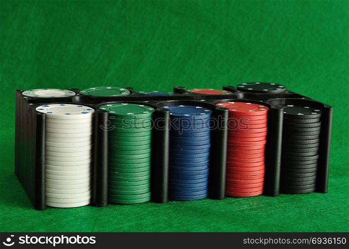 Poker chips displayed in a plastic black container with a green background