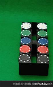Poker chips displayed in a plastic black container with a green background