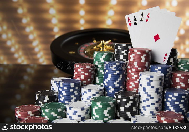 Poker Chips on gaming table, roulette wheel in motion, casino background