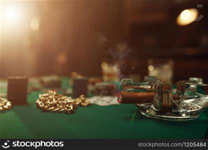 Poker concept, cards and chips on gaming table closeup, whiskey and cigar in casino, nobody. Games of chance. Gambling house business. Poker concept, cards and chips closeup