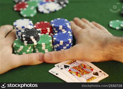 Poker player going &acute;all in&acute; pushing his chips forward