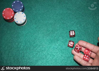 poker player s hand throwing red dices poker table