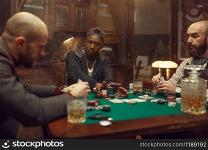 Poker players at gaming table with bets, casino. Games of chance addiction, risk, gambling house. Men leisures with whiskey and cigars. Poker players at gaming table with bets, casino