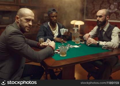 Poker players with cards playing in casino. Games of chance addiction, gambling house. Men leisures with whiskey and cigars