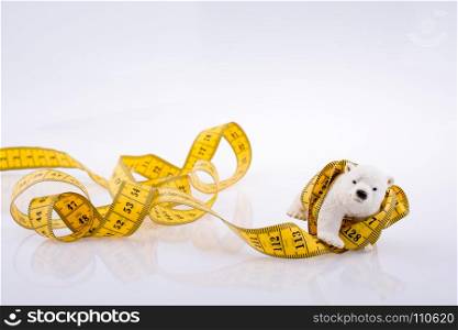 Polar bear surrounded by Measuring tape on a white background