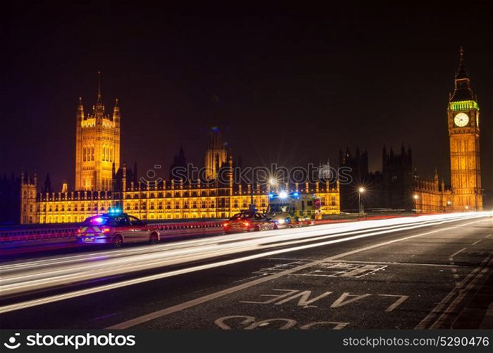 Police Cars and Ambulance on Westminster Bridge, London at Night with The Houses of Parliament and Big Ben