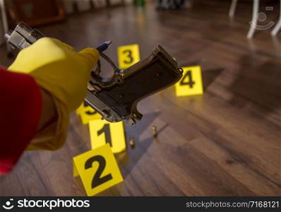 police inspector collects evidence gun at crime scene. Evidence crime scene