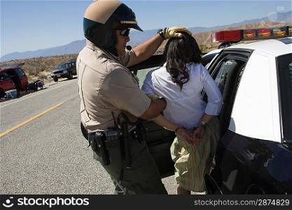 Police man arresting young woman on road