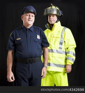 Police officer and firefighter photographed together over a black background.