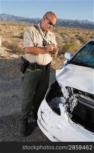 Police officer checking on damaged car