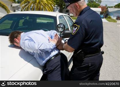 Police officer handcuffing and arresting a well dressed, white collar suspect.