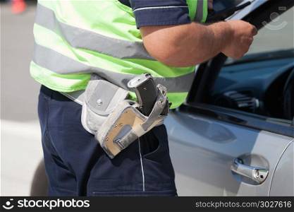 Police officer is checking the driving license of a car driver during a traffic control