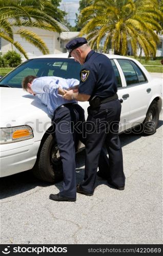 Police officer placing a drunk driver under arrest.