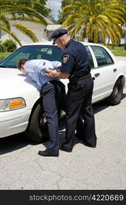 Police officer placing a drunk driver under arrest.