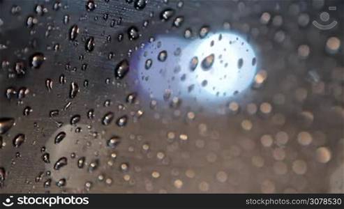 Police rotation light through glass with rain drops