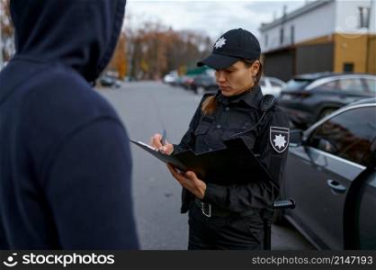 Police woman officer issuing fine ticket to offender. Female cop doing her job. Offense punishment. Police woman officer issuing fine to offender