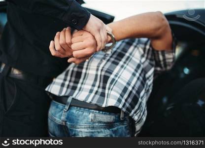 Policeman arrests the car thief on road. Cop at the work. Law protection concept, professional safety control. Policeman arrests the car thief on road