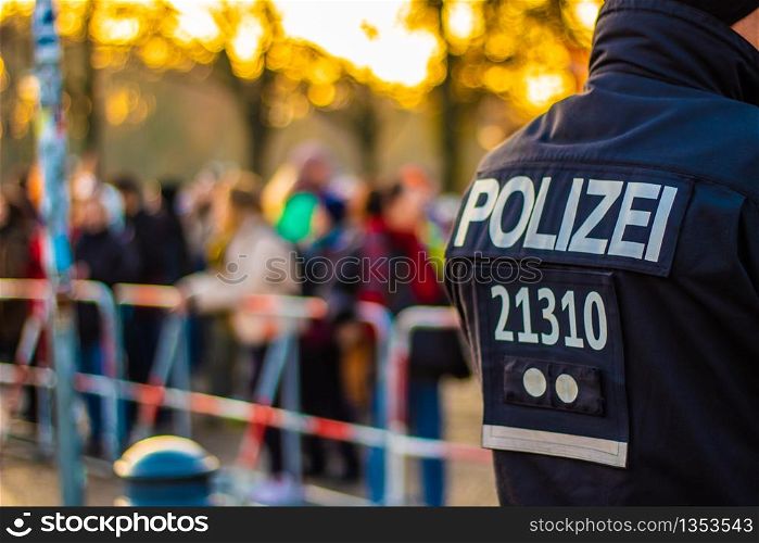 Policeman guarding a safety gate on the edge of a demonstration