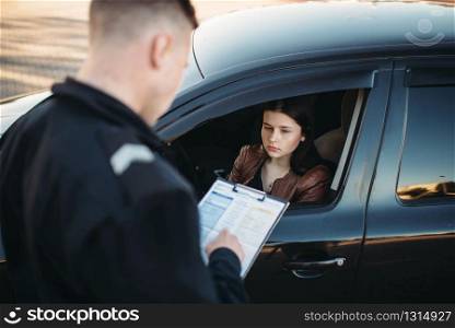 Policeman in uniform writes a fine to female driver. Law protection, car traffic inspector, safety control job. Policeman in uniform writes fine to female driver