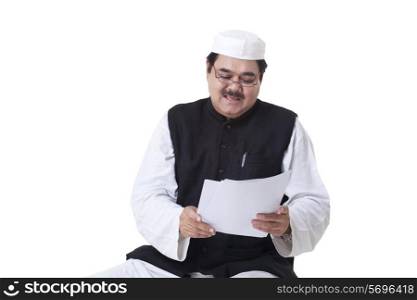 Politician in traditional clothes reading documents