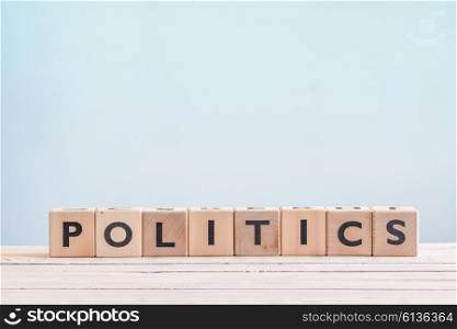 Politics sign made of wooden cubes on a blue background