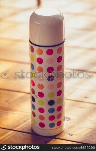 Polka dotted thermos on the floor
