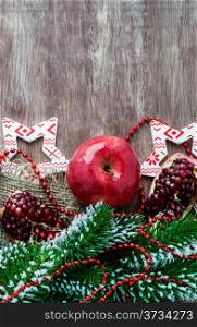 Pomegranate, apple with festive decorations over wooden background, selective focus, copy space