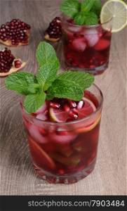 Pomegranate cocktail with slices of lime, mint and ice