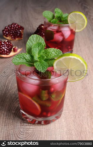 Pomegranate cocktail with slices of lime, mint and ice