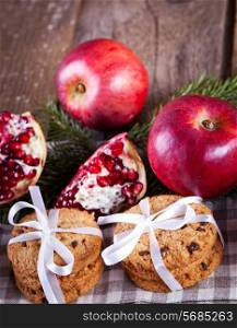 Pomegranate fruit, cookies and apples on wooden background