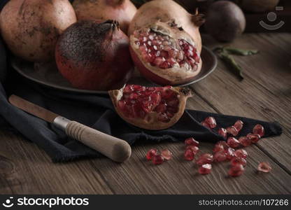 Pomegranate fruit on rustic table in vintage style.