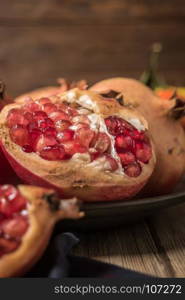 Pomegranate fruit on rustic table in vintage style.