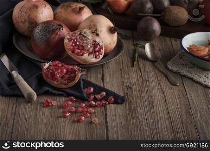 Pomegranate fruit on rustic table in vintage style.