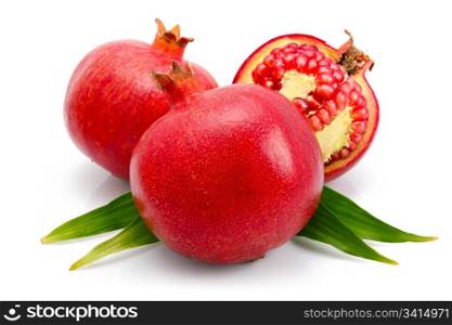 pomegranate fruits with green leaf and cuts isolated on white background