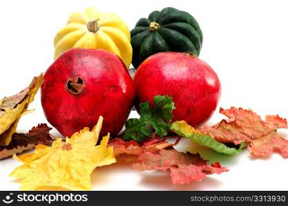 Pomegranate. Green and yellow Acorn squash with Autumn Pomegranates and colorful fall leaves isolated on a white background