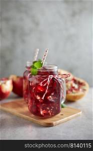 Pomegranate juice in jar with hand≤.  