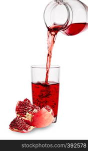 Pomegranate juice pours from jug into glass with piece of pomegranate isolated against a white background. Pomegranate juice pours from jug into glass with piece of pomegr