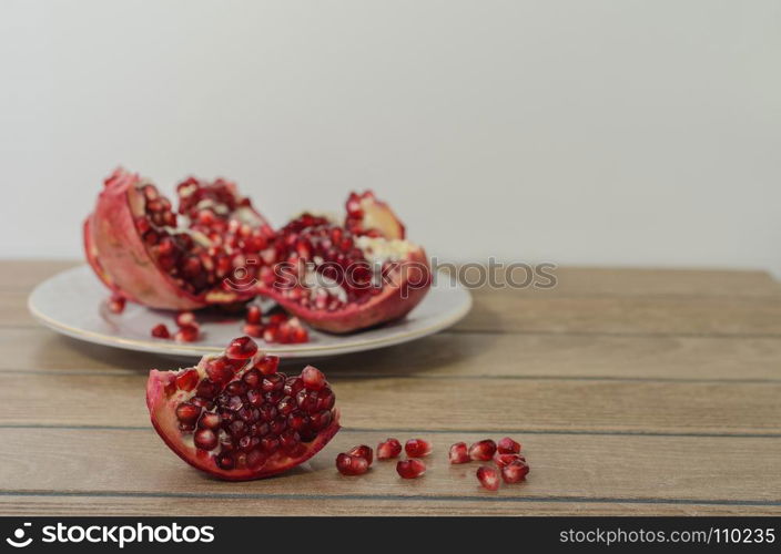 pomegranate on the backgraund, pomegranate slice in front and fallen pomegranate