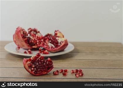 pomegranate on the backgraund, pomegranate slice in front and fallen pomegranate