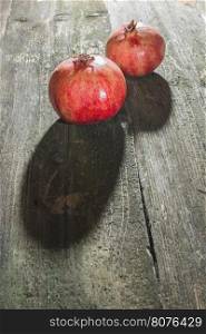 Pomegranate on wooden table. Dirrect light
