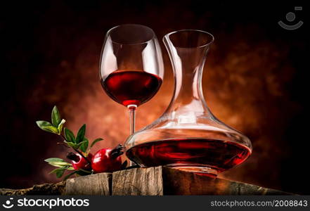 Pomegranate wine on a wooden table in a glass bowl. Pomegranate wine in a decanter