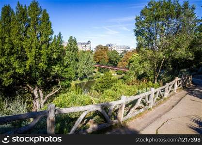 Pond and bridge in Buttes-Chaumont Park in summer, Paris. Pond in Buttes-Chaumont Park, Paris