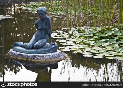 pond with a sculpture and water lilies on Margaret Island in Budapest