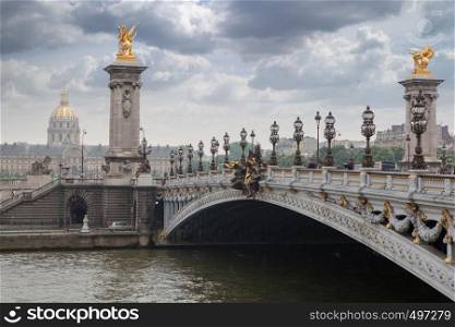 Pont Alexandre III ,Alexandre III bridge autumn in Paris. The most ornate, extravagant bridge in Paris. Pont Alexandre III bridge overlooking the city and the river, cloudy day. France Paris