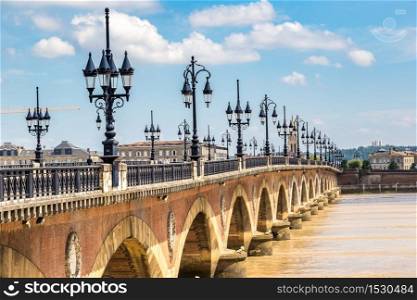 Pont de pierre, old stony bridge in Bordeaux in a beautiful summer day, France