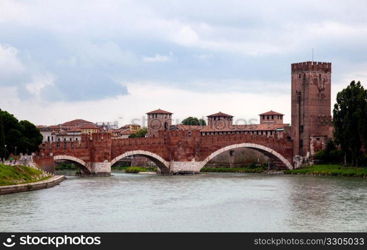 Ponte CastelVecchio in Verona with battlements against the cloudy sky